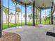 An elegant sunroom offers amazing views with floor to ceiling windows, columns, and sleek concrete floors at 303 Waterwood Dr, Yalaha, FL 34797