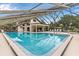 Beautiful screened pool area with lounge chairs and views of community grounds at 303 Waterwood Dr, Yalaha, FL 34797
