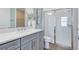 Modern bathroom with a glass-enclosed shower, gray vanity, and contemporary finishes at 3110 Norcott Dr, Davenport, FL 33837