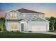 Charming two-story home with a two-car garage, teal door, manicured lawn and lush landscaping at 3110 Norcott Dr, Davenport, FL 33837