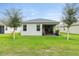 A charming backyard featuring lush green grass, mature trees, and a covered patio at 3412 Yellowtop Loop, Clermont, FL 34714
