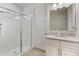 Bathroom showcasing a walk-in shower, white vanity with granite countertop, and wood-look tile flooring at 3412 Yellowtop Loop, Clermont, FL 34714