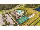 Aerial view of a community pool and tennis courts with palm trees and parking at 3412 Yellowtop Loop, Clermont, FL 34714