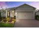 Charming home featuring a well-manicured garden and a brick driveway at 3412 Yellowtop Loop, Clermont, FL 34714