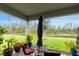 Inviting covered patio with outdoor seating, lush plants, and a serene view of the pond and greenery at 3412 Yellowtop Loop, Clermont, FL 34714