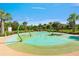 Image featuring a splash pad with colorful surfaces, green water features, and surrounding palm trees at 3412 Yellowtop Loop, Clermont, FL 34714