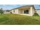 Expansive backyard featuring a covered patio, lush green grass, and a white picket fence, perfect for outdoor enjoyment at 3969 Southern Vista Loop, St Cloud, FL 34772