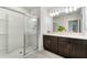 Bright bathroom featuring double vanity with dark brown cabinets and tiled shower at 3969 Southern Vista Loop, St Cloud, FL 34772