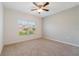 Bright bedroom with a ceiling fan, a window providing natural light, and neutral carpet at 3969 Southern Vista Loop, St Cloud, FL 34772