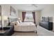 Comfortable bedroom featuring a large bed with decorative pillows, window with curtains, and ceiling fan at 4849 Cypress Woods Dr # 1308, Orlando, FL 32811