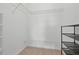 Organized walk-in closet featuring metal shelving and a hanging rod, providing ample storage space in a minimalist design at 4849 Cypress Woods Dr # 1308, Orlando, FL 32811