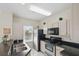 Well-lit kitchen featuring stainless steel appliances, black countertops, and light-colored cabinets at 4849 Cypress Woods Dr # 1308, Orlando, FL 32811