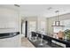 Kitchen view with a sink and black countertop and adjacent dining area with modern lighting at 4849 Cypress Woods Dr # 1308, Orlando, FL 32811