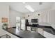 Bright kitchen with stainless steel appliances, black countertops, and white cabinetry at 4849 Cypress Woods Dr # 1308, Orlando, FL 32811
