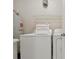 Functional laundry area with a washing machine, dryer, and storage shelf, designed for efficient household tasks at 4849 Cypress Woods Dr # 1308, Orlando, FL 32811