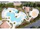 Aerial view of a resort-style pool area with pools, splashpad, sun loungers, umbrellas, and tropical landscaping at 5025 Shoreway Loop # 20503, Orlando, FL 32819