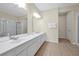 Bright bathroom with double sinks, white cabinetry, large mirror, and glass-enclosed shower at 5025 Shoreway Loop # 20503, Orlando, FL 32819