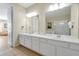 Spacious bathroom featuring double sinks with white vanities, tiled floor, and large mirrors at 5025 Shoreway Loop # 20503, Orlando, FL 32819
