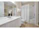 Bright bathroom featuring a shower, vanity with a large mirror, and tile flooring at 5025 Shoreway Loop # 20503, Orlando, FL 32819