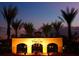 Vista Cay community entrance at dusk, featuring a well-lit sign, lush plants, and palm trees at 5025 Shoreway Loop # 20503, Orlando, FL 32819
