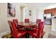 Cozy dining area features a round table with six red leather chairs and adjacent stainless steel refrigerator at 5025 Shoreway Loop # 20503, Orlando, FL 32819