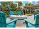 Inviting fire pit area with Adirondack chairs for cozy outdoor gatherings, surrounded by palm trees at 5025 Shoreway Loop # 20503, Orlando, FL 32819