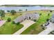 Aerial view of home with large driveway, three-car garage, water view, and green lawn at 534 Two Lakes Ln, Eustis, FL 32726