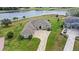 An aerial view showcasing the home, long driveway, backyard, and serene lake at 534 Two Lakes Ln, Eustis, FL 32726