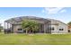 A expansive backyard featuring a screened in patio with outdoor furniture at 534 Two Lakes Ln, Eustis, FL 32726