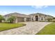 Stunning home featuring a three-car garage, paver driveway, lush landscaping, and elegant architectural details at 534 Two Lakes Ln, Eustis, FL 32726