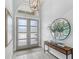 Bright foyer with a modern light fixture, artwork, and wood-look tile flooring at 534 Two Lakes Ln, Eustis, FL 32726