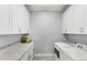 Bright laundry room features white cabinets, granite countertops, and modern washer and dryer at 534 Two Lakes Ln, Eustis, FL 32726