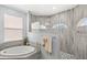 This main bathroom includes a soaking tub, tiled shower with glass enclosure, and natural light at 534 Two Lakes Ln, Eustis, FL 32726
