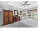 Bright main bedroom features a tray ceiling, ceiling fan, and large windows with views of the backyard at 534 Two Lakes Ln, Eustis, FL 32726