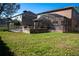 Backyard with a screen-in patio, brick firepit, basketball hoop, and green grass at 535 Belle Fern Ct, Ocoee, FL 34761