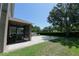 Spacious backyard with a well-maintained lawn, screened-in porch, and mature trees at 535 Belle Fern Ct, Ocoee, FL 34761