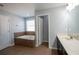 Bright bathroom featuring a tiled tub, neutral walls, and a vanity with countertop space at 535 Belle Fern Ct, Ocoee, FL 34761