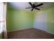 Bedroom with neutral carpet, green walls, ceiling fan, and closet with bi-fold doors at 535 Belle Fern Ct, Ocoee, FL 34761