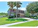 Charming two-story home featuring a well-maintained lawn, brick driveway, and lush landscaping at 535 Belle Fern Ct, Ocoee, FL 34761