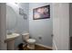 Cozy half bathroom featuring a pedestal sink, a framed floral art piece, and decorative wall art at 535 Belle Fern Ct, Ocoee, FL 34761