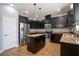 Dark wood kitchen with stainless steel appliances, granite countertops, and central island at 535 Belle Fern Ct, Ocoee, FL 34761