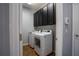 Convenient laundry room with a modern washer and dryer, as well as overhead cabinets at 535 Belle Fern Ct, Ocoee, FL 34761