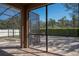 View of the outdoor basketball court and backyard from the tiled screened porch at 535 Belle Fern Ct, Ocoee, FL 34761