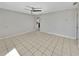 Open living room boasts neutral paint, ceramic tile flooring, and a ceiling fan at 5825 Hafer Ln, Orlando, FL 32808