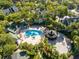 An aerial view of the community pool and barbecue area surrounded by lush landscaping and palm trees at 6178 Westgate Dr # 304, Orlando, FL 32835