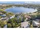 Aerial view of a beautiful home nestled among mature trees and fronting a picturesque lake at 641 Lake Catherine Dr, Maitland, FL 32751