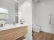 Modern bathroom with wood grain vanity, large mirror, sleek fixtures, and floating toilet at 641 Lake Catherine Dr, Maitland, FL 32751