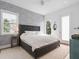 A modern bedroom with a patterned accent wall, large window, ceiling fan and tufted headboard bed frame at 641 Lake Catherine Dr, Maitland, FL 32751