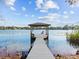Scenic view of a private wooden dock and gazebo on a calm lake under a sunny sky at 641 Lake Catherine Dr, Maitland, FL 32751