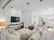 Bright living room features hardwood floors, TV, and white sectional couch, perfect for relaxing and entertaining at 641 Lake Catherine Dr, Maitland, FL 32751